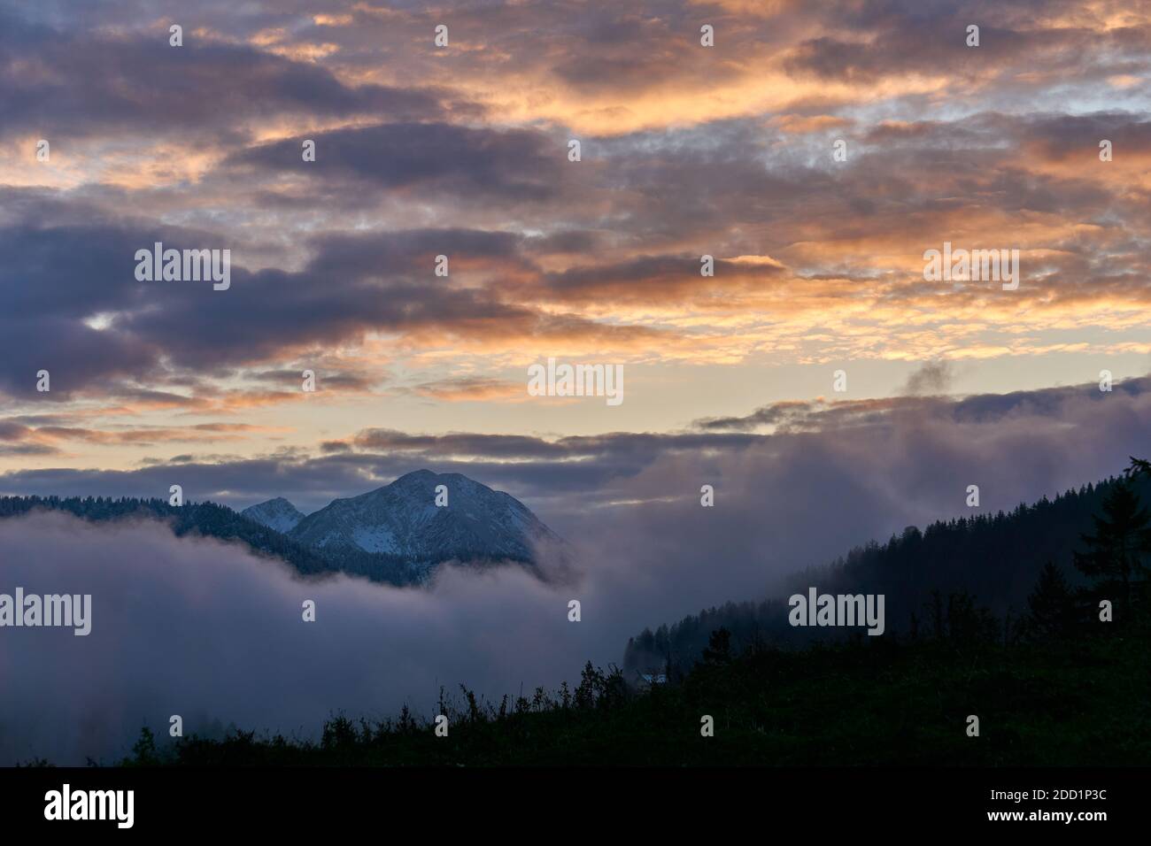 La montagna Hochmiesing al sole tramonta con nuvole illuminate dal sole Foto Stock