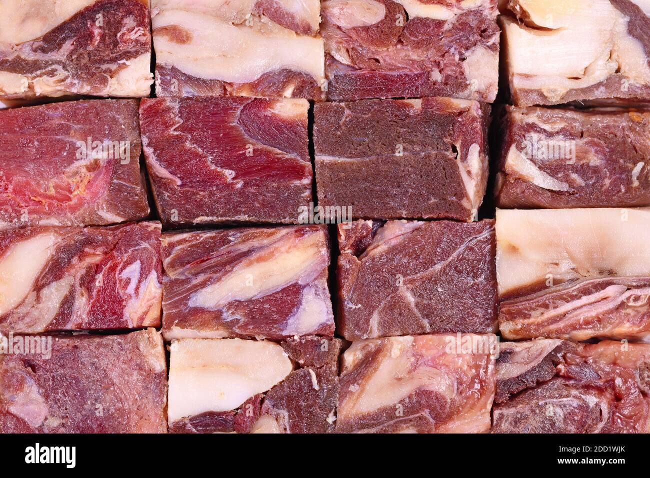 Grossi pezzi di carne rossa striata con un sacco di grasso usato per l'alimentazione grezza di cani o gatti Foto Stock