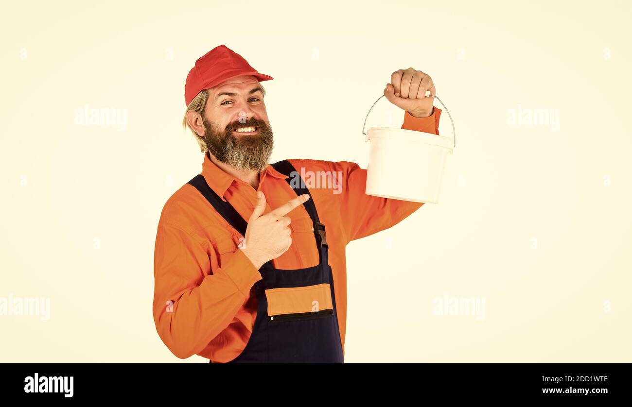 Applicare intonaco per rifinire le pareti interne. Uomo maturo bearded pittore. Costruzione e ristrutturazione. Decorazioni e decorazioni. Pittore di parete con secchio di vernice. Pittore hipster. I pittori lavorano. Foto Stock