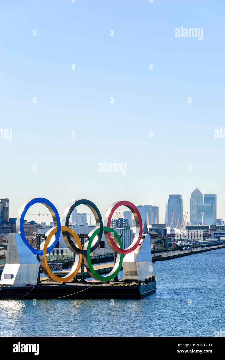 Regno Unito, Londra. Logo olimpico, dock di King George V. Alto Canary Wharf, Millenium Stadium (O2 Centre), London City Airport e Excel Centre (a destra). 2012. Foto Stock