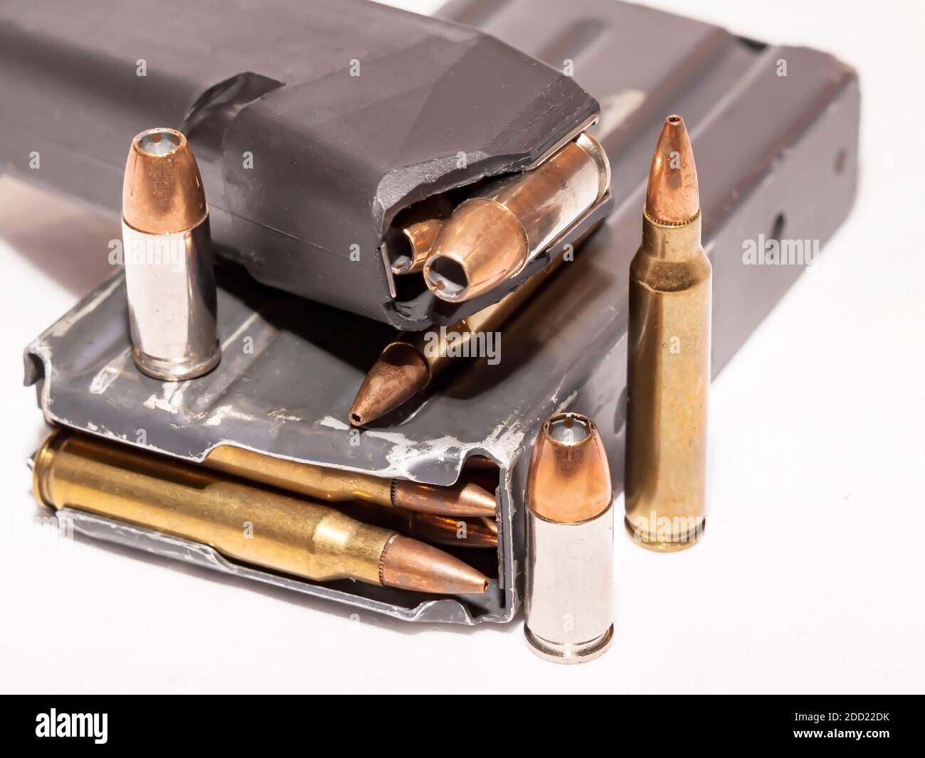 Due riviste, una per una pistola da 9 mm e l'altra per un calibro 223 caricato con proiettili su sfondo bianco Foto Stock