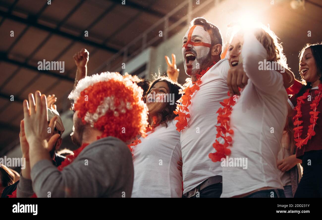 Entusiasma i fan con la folla che festeggia il successo della squadra. Gruppo di tifosi di calcio inglesi che si acclamano in stand. Foto Stock