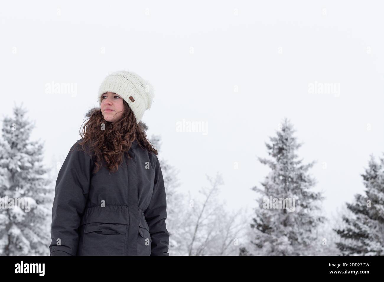 Giovane adulto, bella ragazza teen, indossando abiti invernali in piedi fuori con gelo e neve su alberi MR immagini di persone con un sacco di spazio di copia Foto Stock