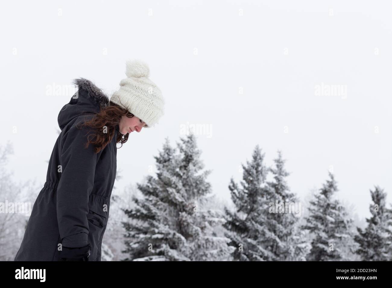 Teen girl, giovane adulto, che cammina fuori in inverno, gelo e neve, in profilo MR immagini di persone con un sacco di spazio di copia Foto Stock