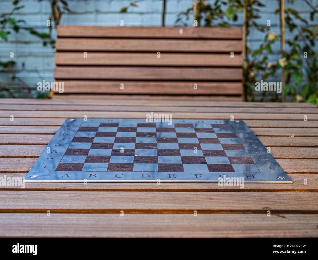 Una scacchiera nel parco. Una panchina di legno e un tavolo da scacchi nel parco. Foto Stock