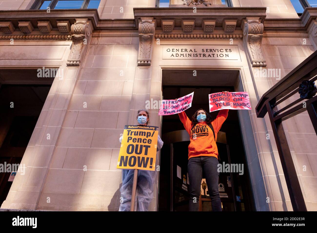 Washington, DC, USA, 23 novembre 2020. Nella foto: La portavoce del fascismo dei rifiuti Sunsara Taylor e il membro Lucha Bright si trovano di fronte all'edificio della General Services Administration (GSA) durante la protesta della Body Bag. I membri del fascismo dei rifiuti DC in PPE hanno trasportato borse per il corpo che rappresentano gruppi di persone che sono morte di Covid. I dimostranti hanno marciato verso l'edificio della GSA per chiedere che Emily Murphy rilasci denaro e risorse dovute al team di transizione di Biden, per prevenire infezioni e morti inutili. Ha liberato i soldi più successivamente nel giorno. Credit: Alison C Bailey/Alamy Live News Foto Stock