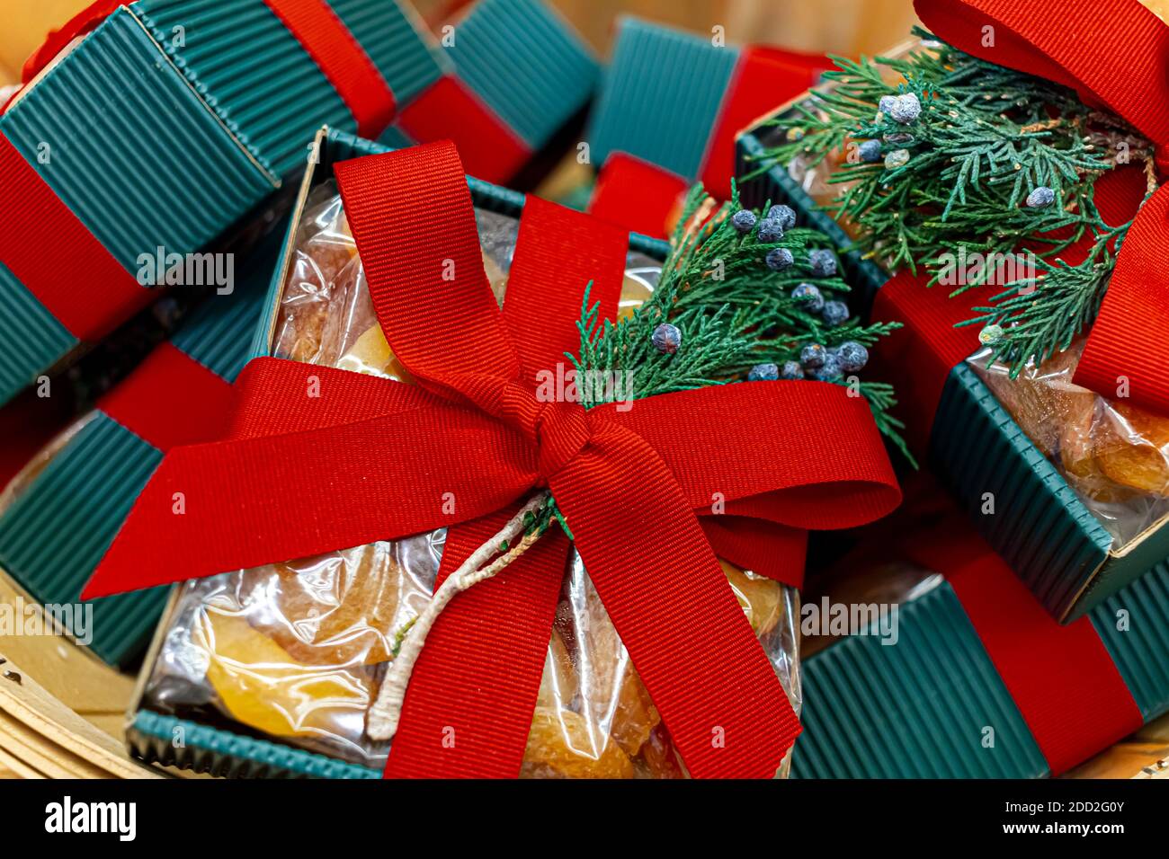 Primo piano immagine isolata di un mucchio di regali di natale ciascuno messo su scatole quadrate blu e avvolto con nastri rossi. Ciascuno ha un pezzo di abete con c blu Foto Stock