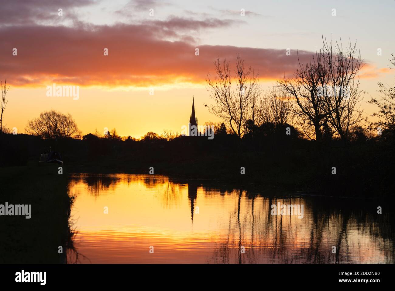 La chiesa di Kings Sutton si riflette nel canale di Oxford all'alba in autunno. Kings Sutton, confine tra Oxfordshire e Northamptonshire, Inghilterra. Silhouette Foto Stock