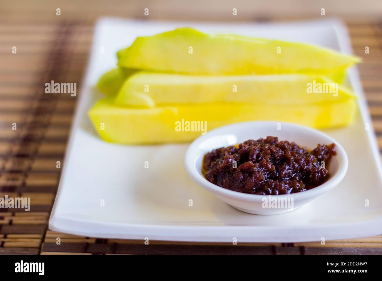 Fettine di mango verde con pasta tradizionale di gamberetti fermentati filippini Foto Stock