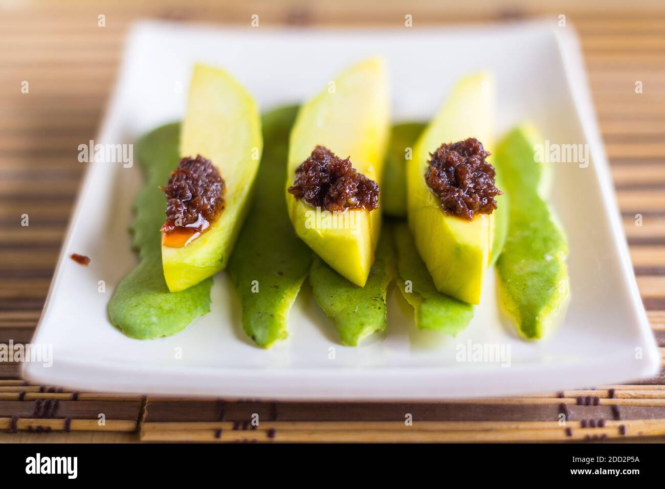 Fettine di mango verde con pasta tradizionale di gamberetti fermentati filippini Foto Stock