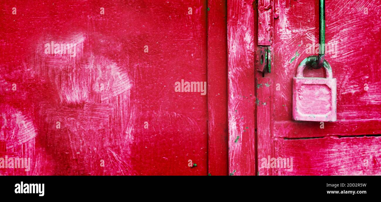 Lucente lucchetto rosa appeso alla porta del garage arrugginita. Sbloccare dati, informazioni sicure. Amore e concetto di relazione. Foto Stock