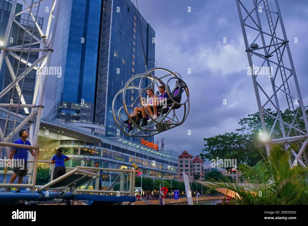 Giovani turisti occidentali che cercano apprensione prima di essere trascinati in aria capovolta al G-MAX Reverse Bungy a Clarke Quay, Singapore Foto Stock