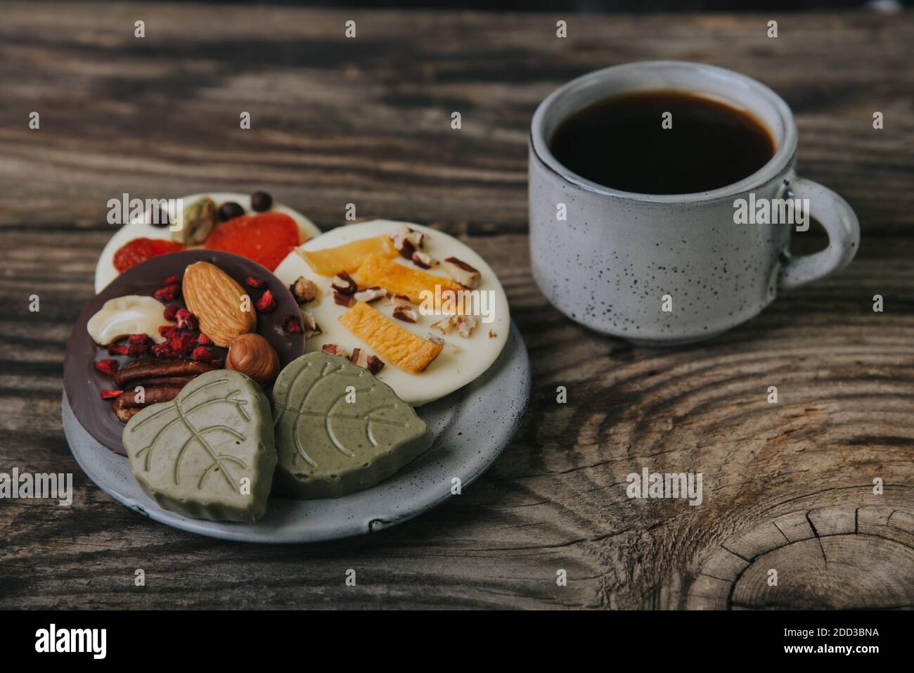 Cioccolatini con frutta secca e una tazza di caffè espresso. Foto Stock Cioccolatini con frutta secca e una tazza di caffè espresso. Foto Stock