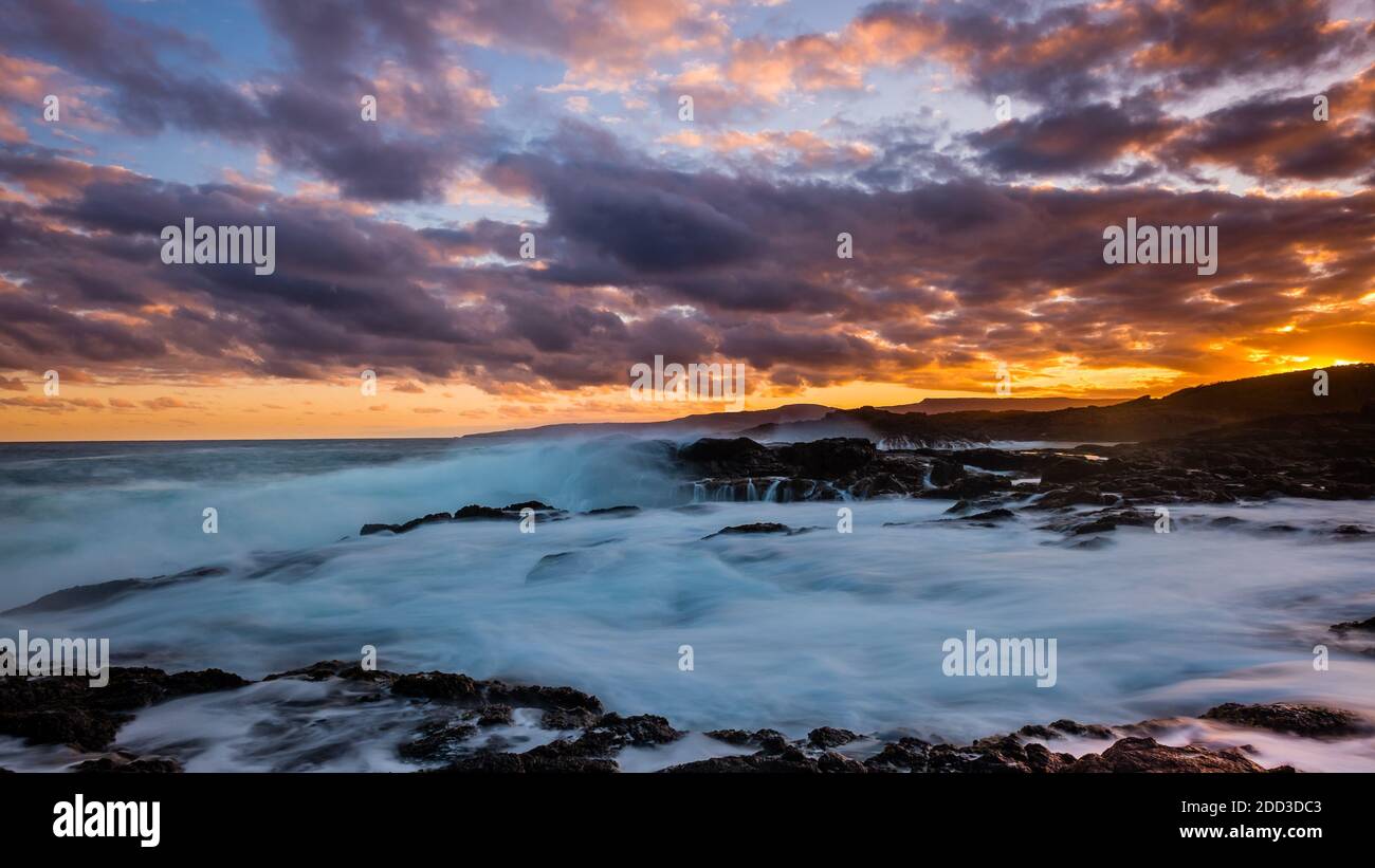 Cielo al tramonto e onde acquatiche a Bushrangers Bay Foto Stock
