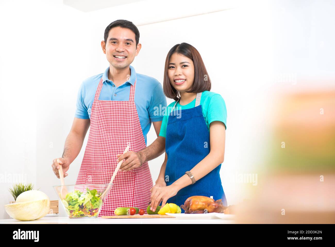 Felice cucina asiatica coppia a casa Foto Stock