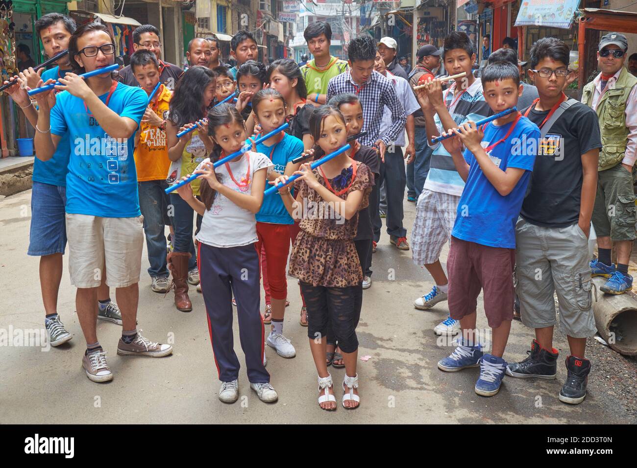In una giornata di festival indù, giovani studenti nepalesi suonano flauto per le strade di Kathmandu, Nepal Foto Stock