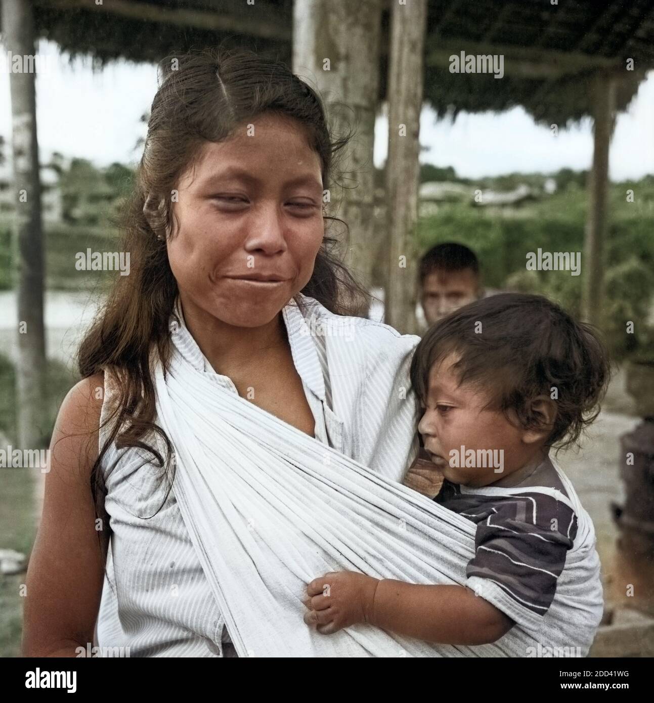 Eine Mutter mit ihrem tipo auf einer Straße in der Stadt Purto Napo, Ecuador 1960er Jahre. Una madre con il suo bambino per le strade della città di Puerto Napo, Ecuador 1960s. Foto Stock