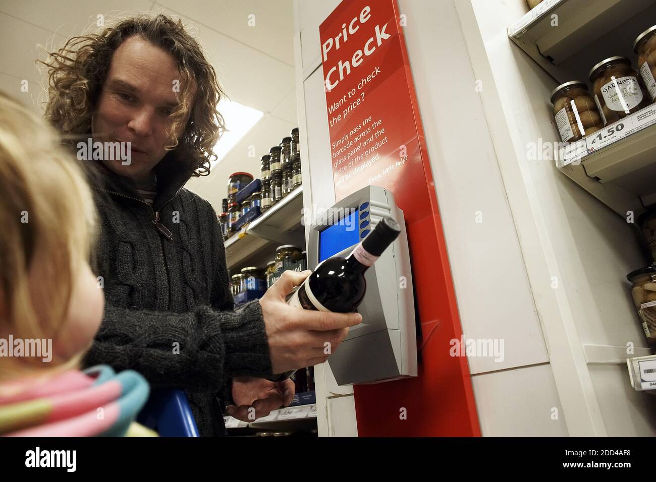 il cliente controlla il prezzo nel negozio utilizzando lo scanner Foto Stock