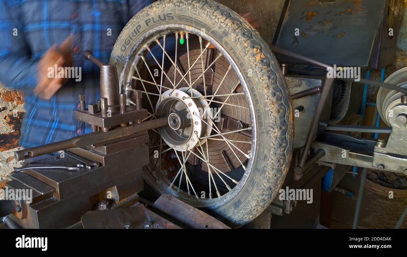 Novembre 2020- Mahroli, Jaipur, India / primo piano vista di pneumatico Bike, montaggio su tornio macchina per la riparazione. Foto Stock