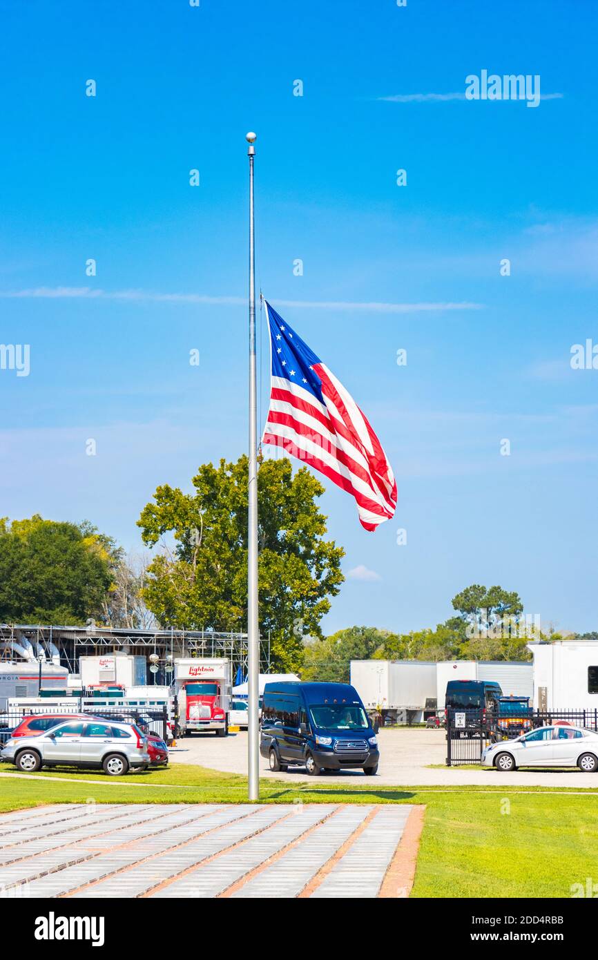 Stelle degli Stati Uniti e bandiera a strisce che volano a metà del personale contro il cielo blu Foto Stock