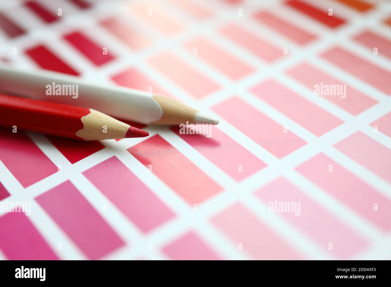Matita rossa e bianca giacciono sul primo piano della tavolozza dei colori sfondo Foto Stock