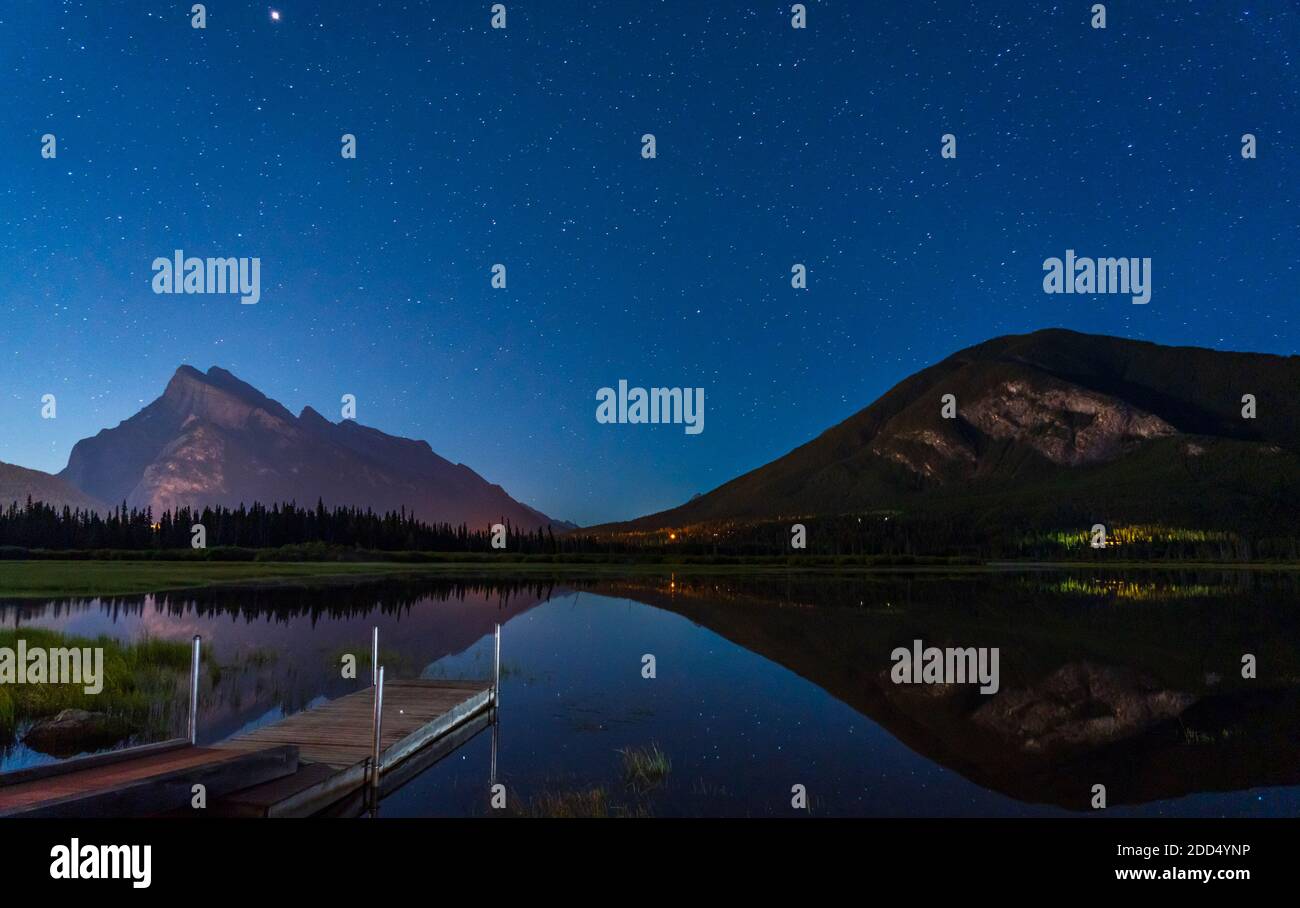 Vermilion Lakes Viewpoint di notte, pieno di stelle sopra il Monte Rundle, cielo stellato riflesso nella superficie dell'acqua. Paesaggio nel Parco Nazionale di Banff Foto Stock