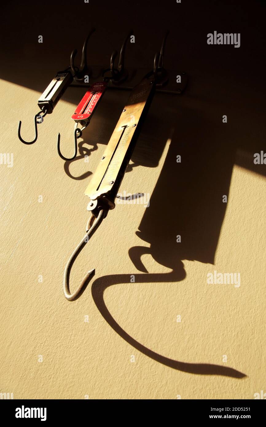 Tre bilance a molla per la misurazione dei pesi degli articoli appesi ai ganci. Foto Stock Tre bilance a molla per la misurazione dei pesi degli articoli appesi ai ganci. Foto Stock