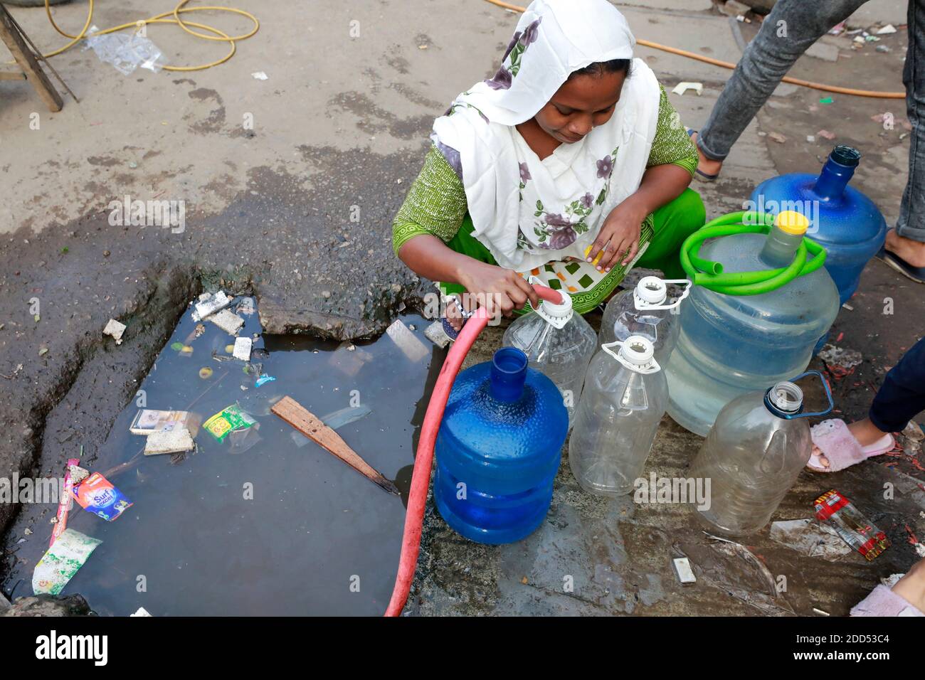 Dhaka, Bangladesh - 24 novembre 2020: I residenti di Fulbari a Dhaka, Bangladesh, raccogliere l'acqua da un tubo di strada. La crisi idrica è diventata acuta in t Foto Stock