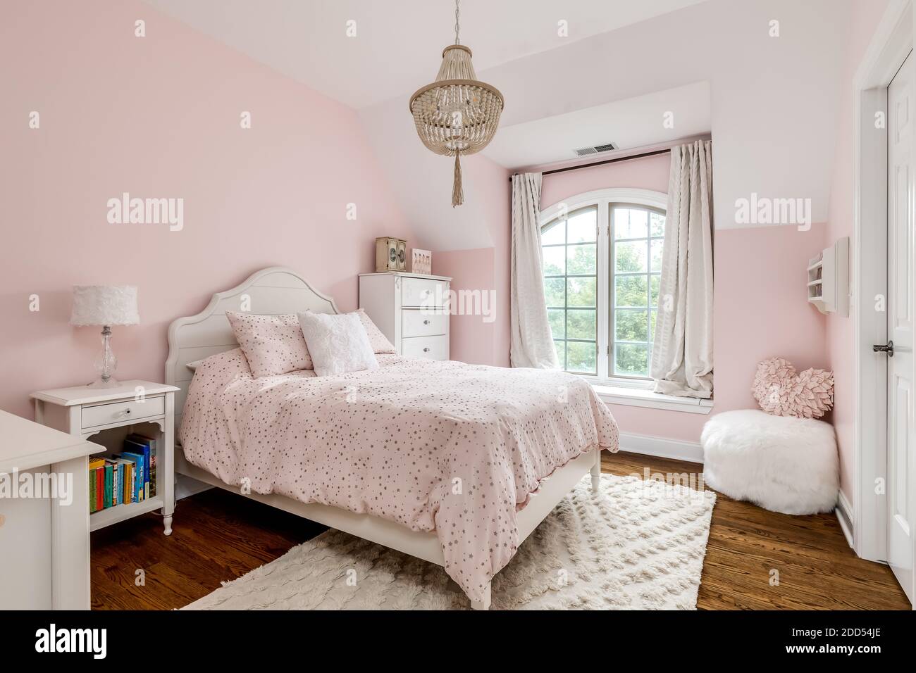 Una camera da letto per ragazze con pareti rosa e un lampadario in corda  d'oro appeso sopra il letto Foto stock - Alamy