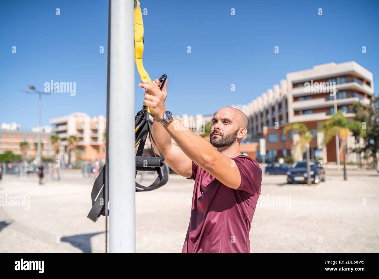 Personal trainer che si prepara ad allenarsi con TRX in una città impostazione Foto Stock