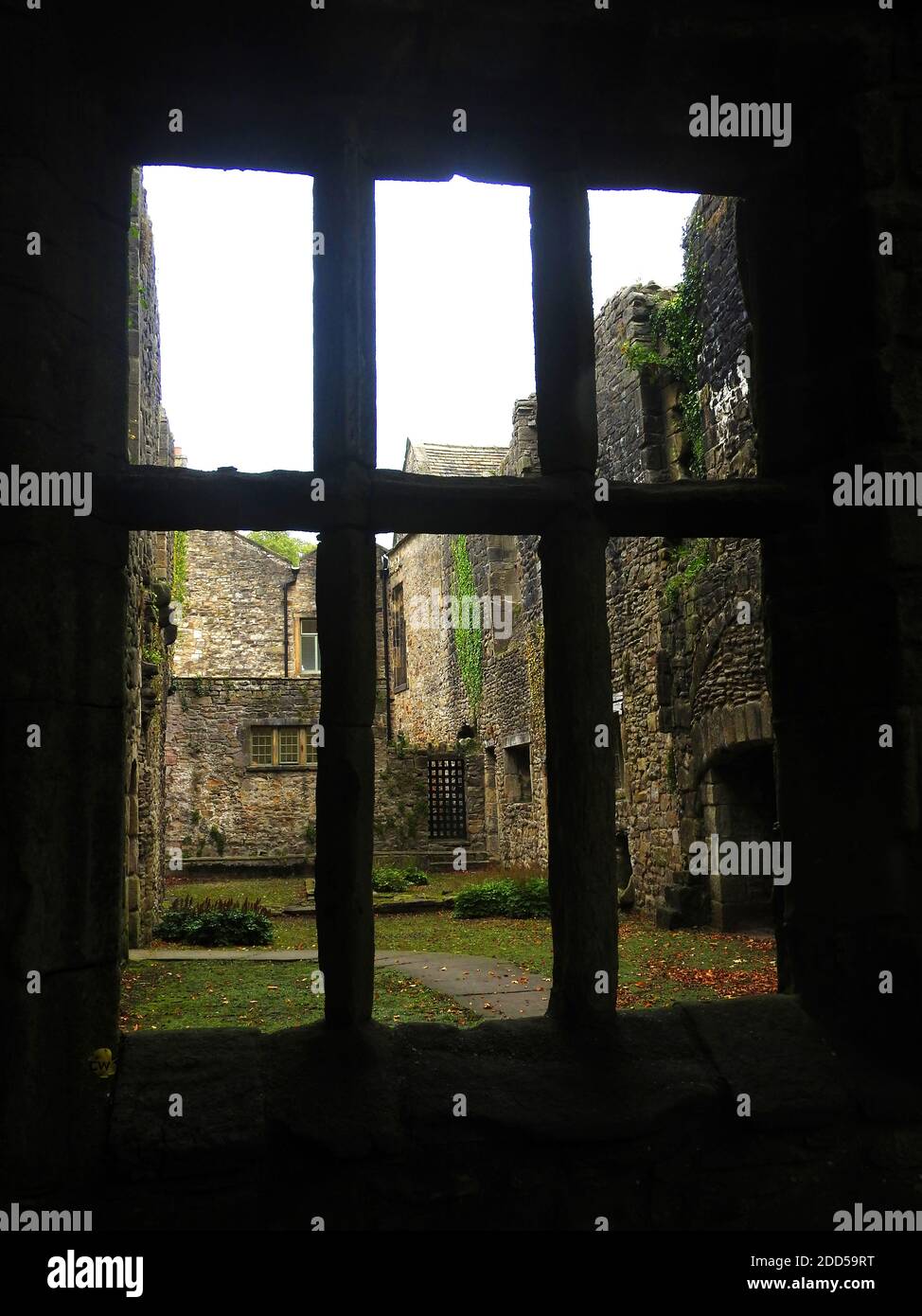 La cucina di Abbot visto attraverso una finestra incorniciata in pietra a Whalley Abbey , Lancashire , Regno Unito nel 2020) - nel 1296 i monaci di Stanlow Point, Cheshire si trasferirono a nord a Whalley, Lancashire, dove costruirono un nuovo monastero accanto al fiume Calder. Vi era già una cappella sul sito, eretto da Pietro di Chester, il rettore di Whalley e che l'edificio del 13 ° secolo è stato incorporato nel nuovo monastero. La pietra di fondazione per la nuova chiesa abbaziale fu posata nel giugno 1296 da Henry de Lacy, il 10° barone di Halton. Foto Stock