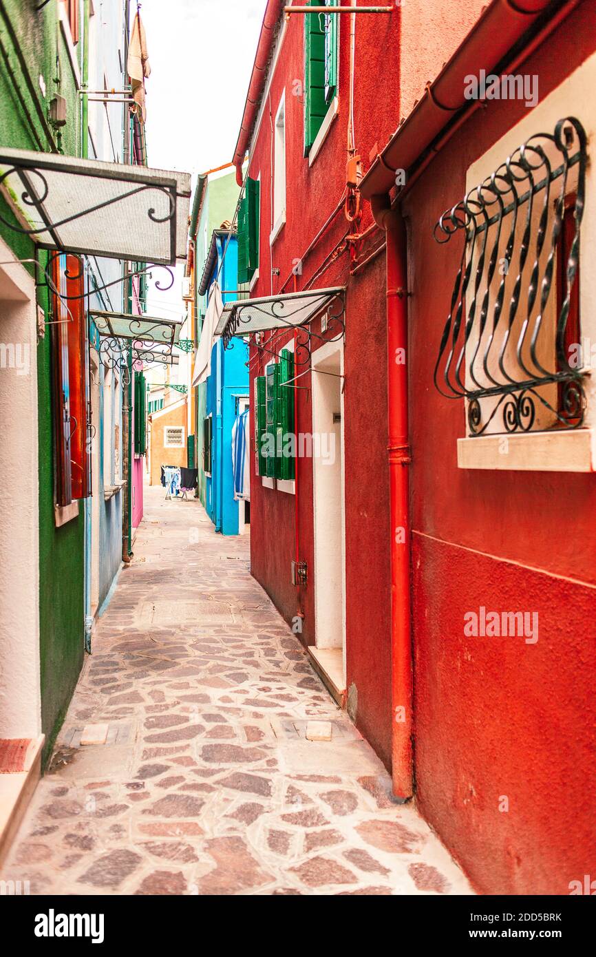 Strada stretta con case colorate sull'isola di Burano, Venezia, Italia Foto Stock