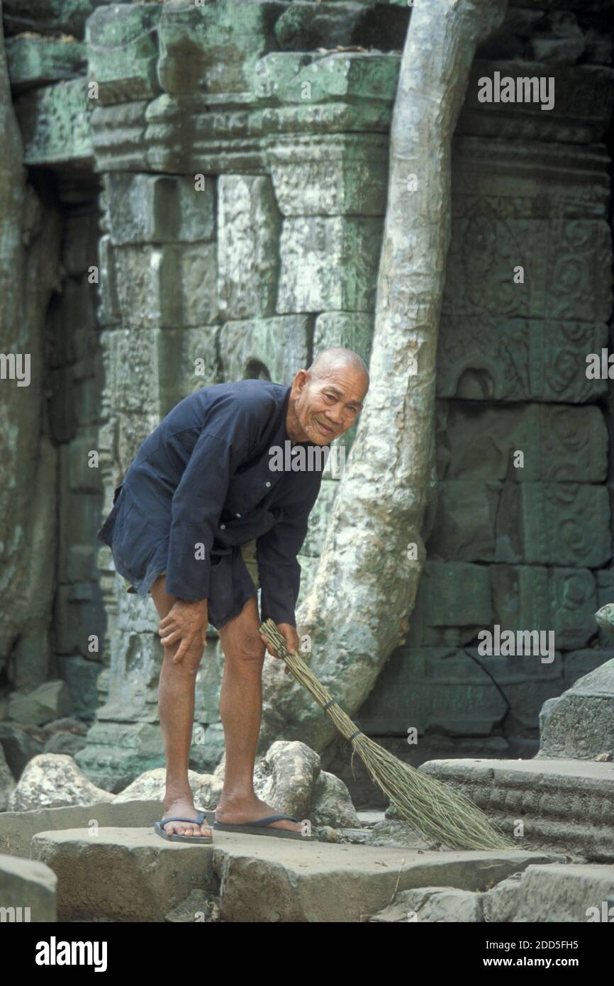 Gli uomini vecchi con il nome Prohm sta clining il tempiale con il suo nome Ta, gli uomini vecchi e il suo secondo nome Prohm. Mister Ta Prohm nel tempio Ta Prohm in Foto Stock