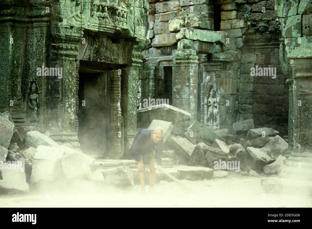 Gli uomini vecchi con il nome Prohm sta clining il tempiale con il suo nome Ta, gli uomini vecchi e il suo secondo nome Prohm. Mister Ta Prohm nel tempio Ta Prohm in Foto Stock