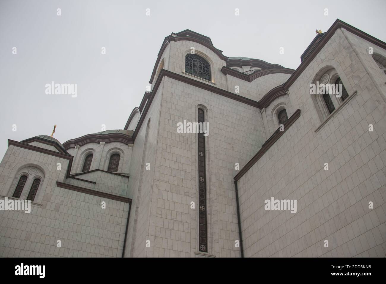 Dettagli del tempio di San Sava (Hram Svetog Save, in serbo), finestre e cupola con croce dorata sulla parte superiore, potenti pareti bianche. Foto Stock