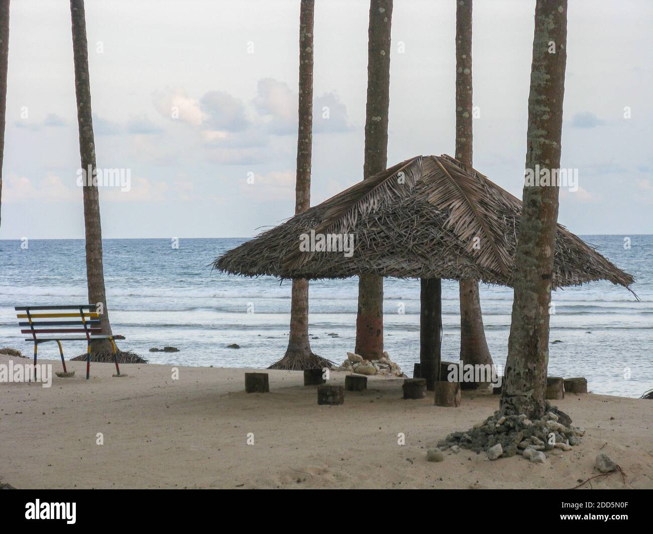 Immagine di silhouette di una tonalità di paglia con una panca a. Siediti su una spiaggia a Port Blair in Andaman e. Nicobar Isole India Foto Stock