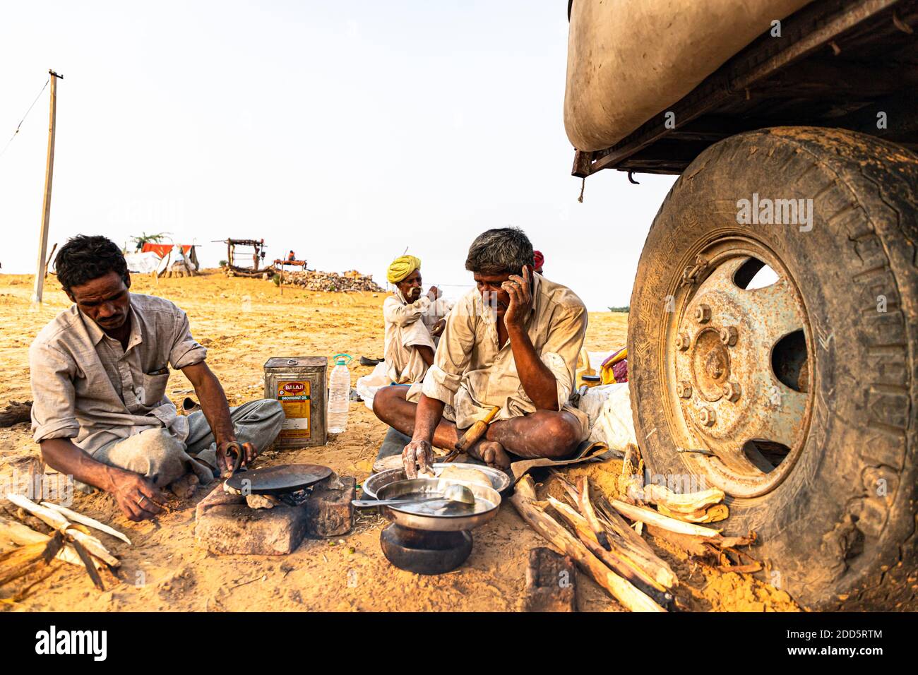 uomo nomadico rajasthani che fa cibo in cucina aperta. Foto Stock