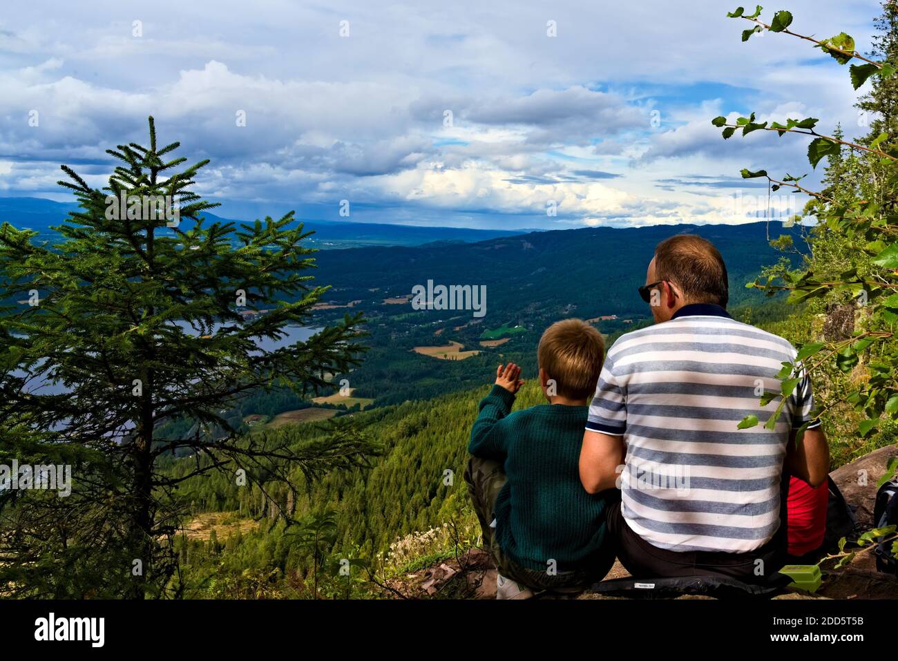 Sundvollen, Norvegia - 5 settembre 2020: Padre e figlio escursionista seduti insieme su una roccia godendo di una vista sulle montagne. Foto Stock