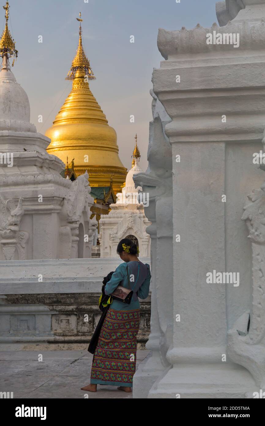 Giovane donna in piedi a Kuthodaw Pagoda, Mandalay, Myanmar (Birmania), Asia nel mese di febbraio - vista posteriore da dietro Foto Stock