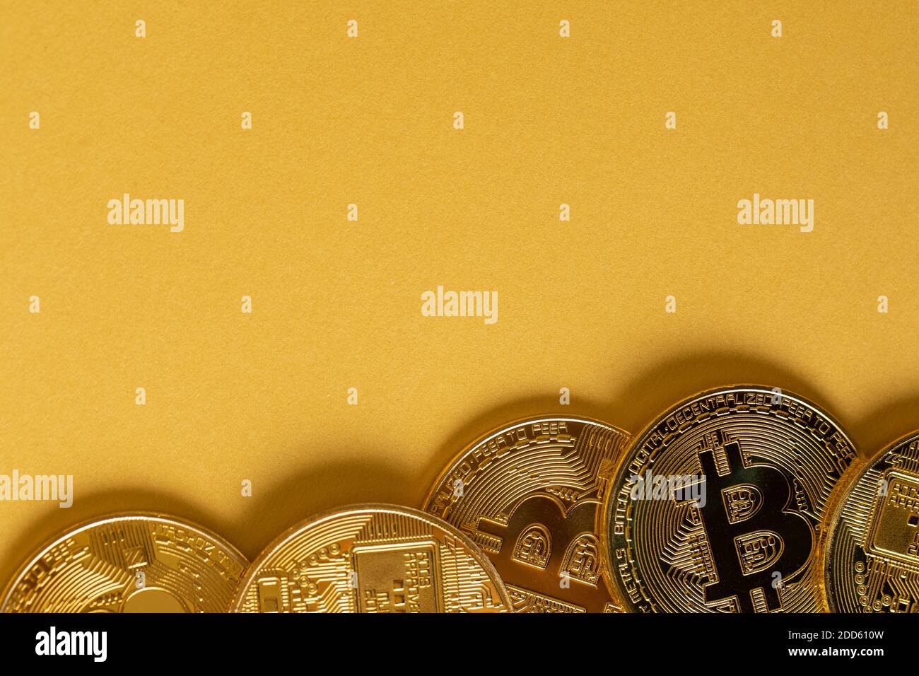 Monete d'oro Bitcoin giacenti su sfondo dorato Foto Stock