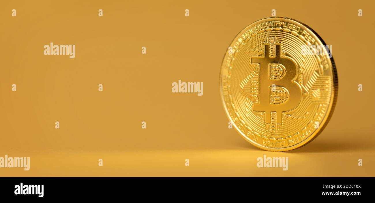 Moneta criptovaluta Bitcoin in piedi su sfondo dorato Foto Stock