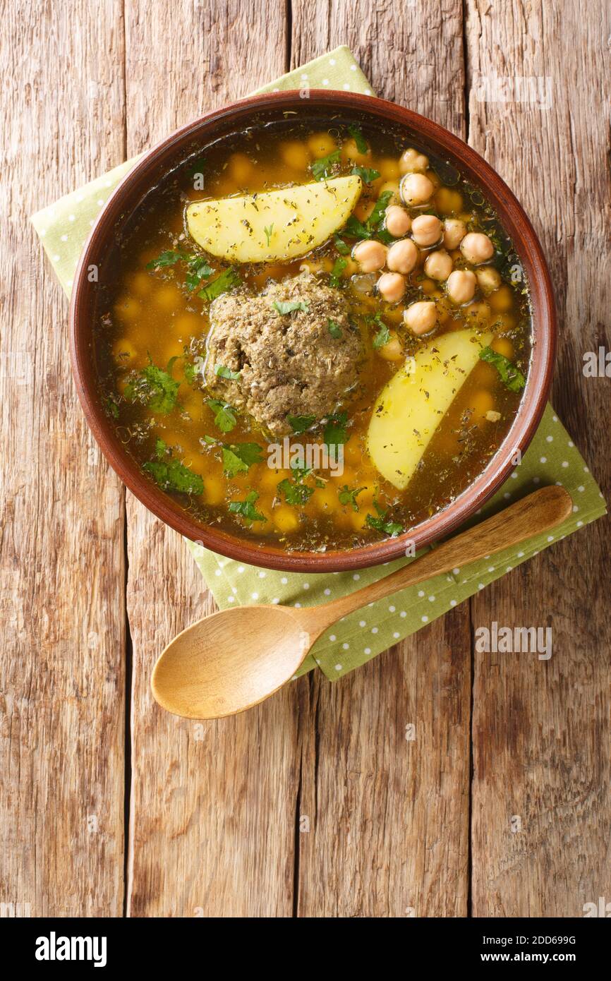 Il bozbash Kufta fatto in casa è una tradizionale zuppa di polpette azerbaigiane e un primo piano di ceci in un piatto sul tavolo. Vista dall'alto verticale Foto Stock