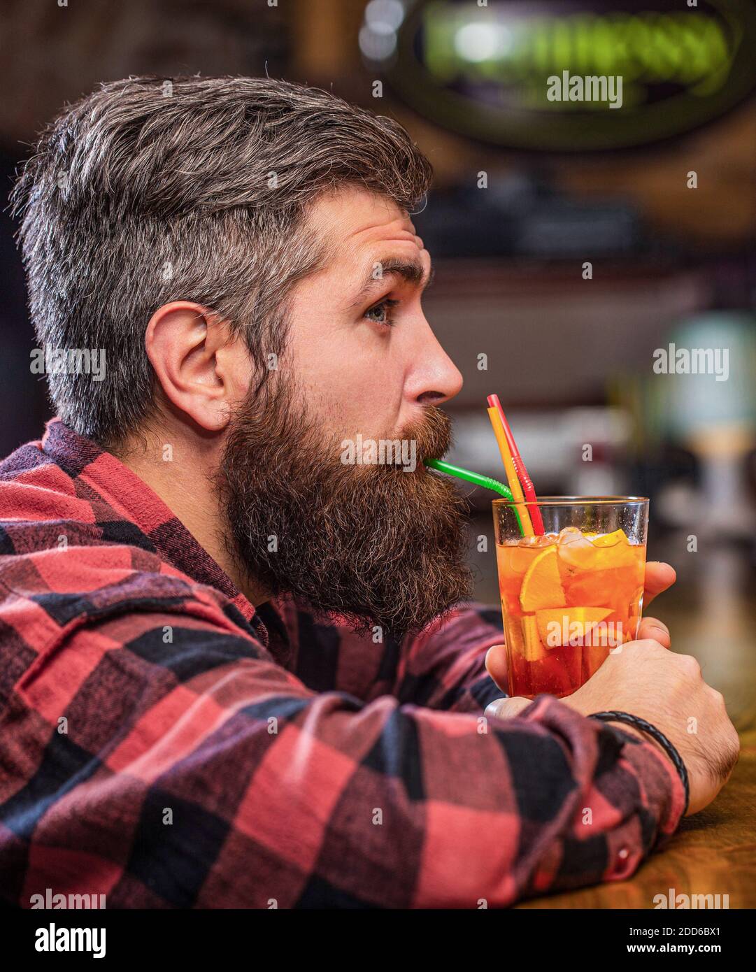 Cocktail tropicale fresco alcolico. Barman in pub o ristorante. Cocktail uomo bearded. Uomo ritratto, bevendo succo d'arancia. Cocktail bearded man drink Foto Stock