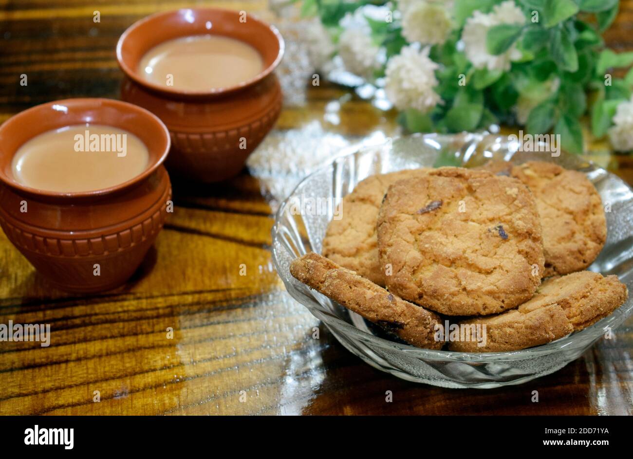 Tè in tazza di argilla ' MATIR BHAR' fatta a mano indiana con Biscotti fatti in casa in una ciotola di vetro Foto Stock