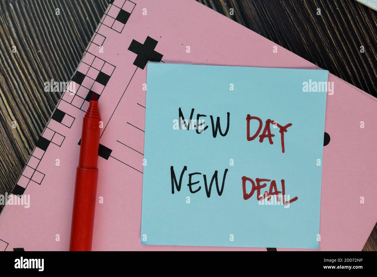 New Day - New Deal scrivere su note appiccicose isolate su tavolo di legno. Foto Stock