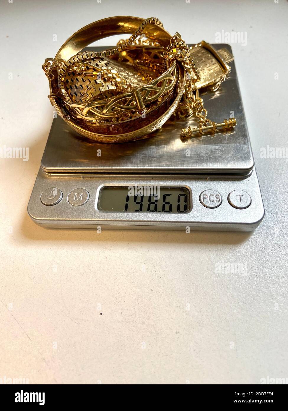Oro rottami catene di palo e gioielli di bangle su scala essere pesato al  negozio di pegno Foto stock - Alamy
