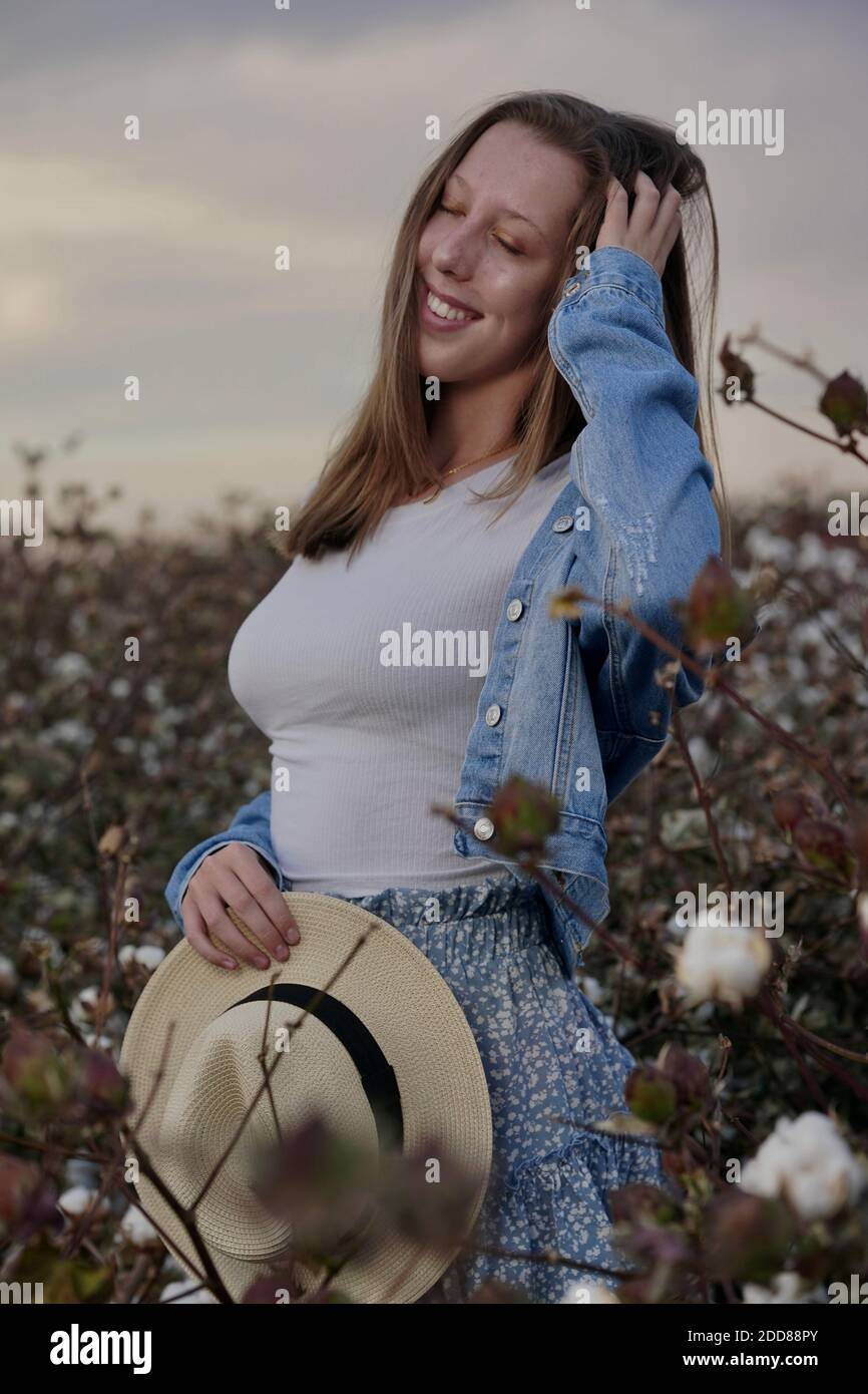 Una ragazza adolescente posa in un campo di cotone. Foto Stock