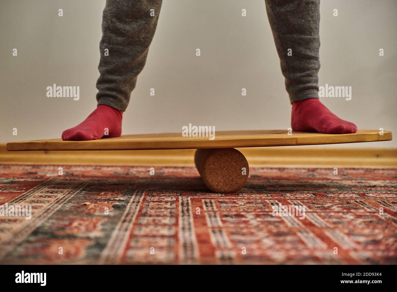 Persona in piedi su una tavola di bilanciamento di legno. Bilanciamento di una persona su un bordo di equilibrio. Foto Stock