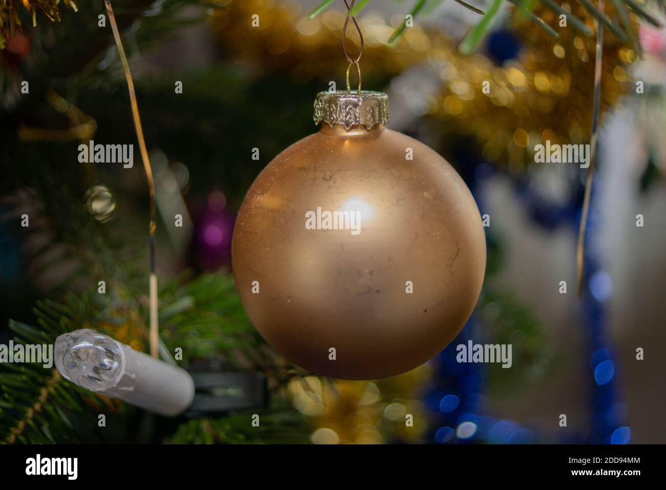 Krofoto von einer goldenen weihnachtskugel, die am Weihnachtsbaum hängt. Foto Stock