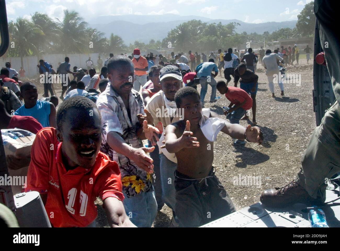NO FILM, NO VIDEO, NO TV, NO DOCUMENTARIO - i cittadini haitiani ricevono acqua dai crewmen aerei da Helicopter Sea Combat Squadron (HSC) 9, assegnato alla portaerei USS Carl Vinson, a Port-au-Prince, Haiti, Sabato, 16 gennaio 2010. Carl Vinson e Carrier Air Wing (CVW) 17 stanno conducendo operazioni umanitarie e di soccorso in caso di terremoto di magnitudine 7.0 causato gravi danni vicino a Port-au-Prince il 12 gennaio 2010. Foto di Aaron Shelley/US Navy News Photo/MCT/ABACAPRESS.COM Foto Stock